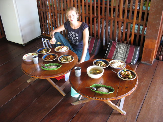Prêts à déguster nos préparations ; devant Maïte, dans les trois plats bleus, de gauche à droite : légumes aigre-doux, curry panang, pad thai, dans le plat vert en forme de feuille de banane : riz collant sucré au lait de coco, dans le bol blanc sur l'autre table : curry vert IMG_0830.JPG