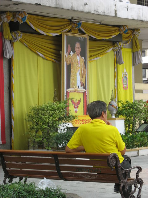 Personne habillée en jaune, couleur du roi, portée par la plupart des gens le lundi, jour du roi, devant une des nombreuses représentations du souverain, très vénéré dans son pays IMG_2122.JPG